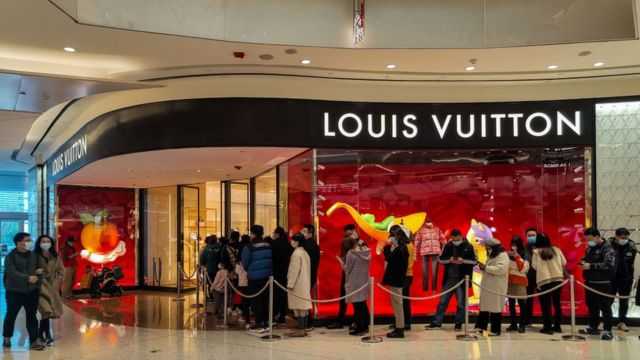 Chinese shoppers queue in front of luxury store