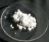 White lumped powder on a glass plate