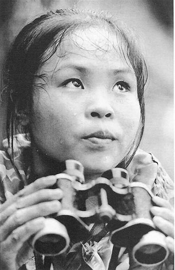 Bức ảnh chụp bà La Thị Tám đang cầm ống nhòm đếm bom của nhiếp ảnh gia Văn Bảo.
